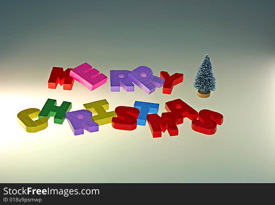 Merry Christmas wood letters and small christmas tree with warm light