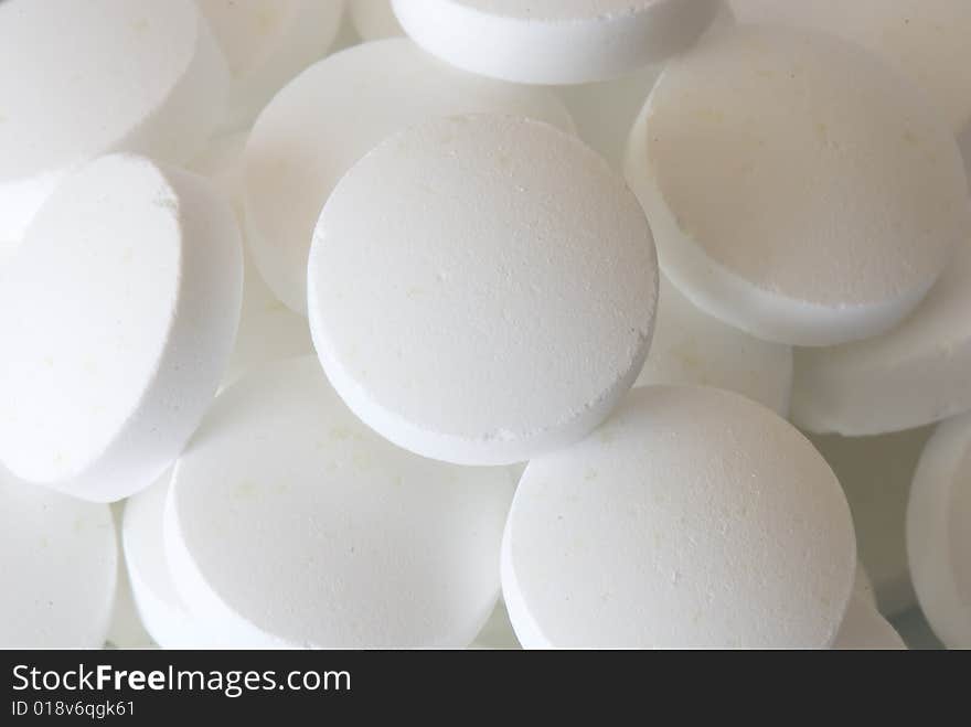 White round vitamins on the white isolated background