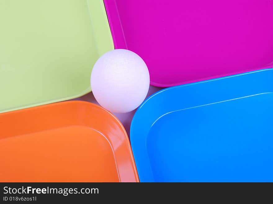 White egg among colorful plates. White egg among colorful plates