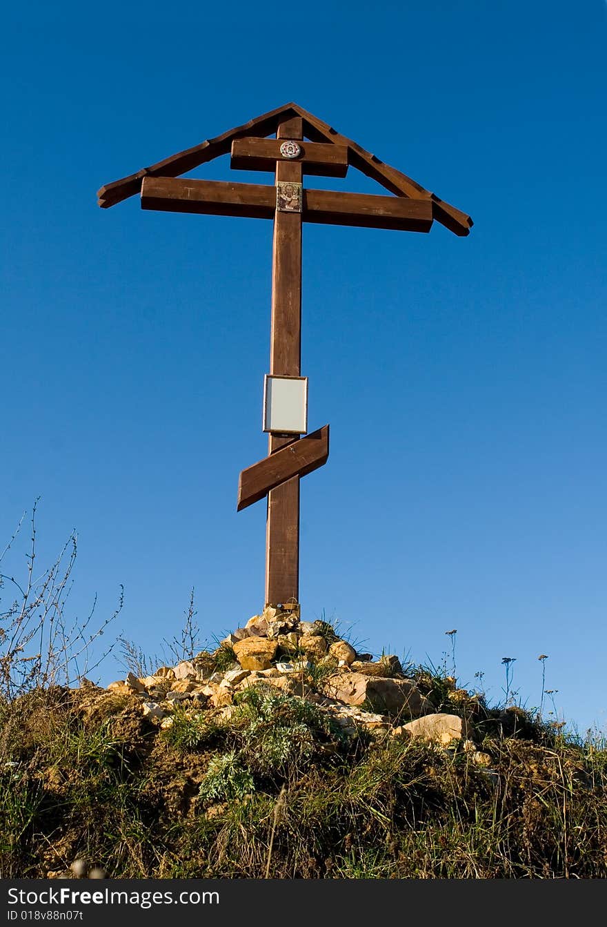 Cross on the hill behind blue sky