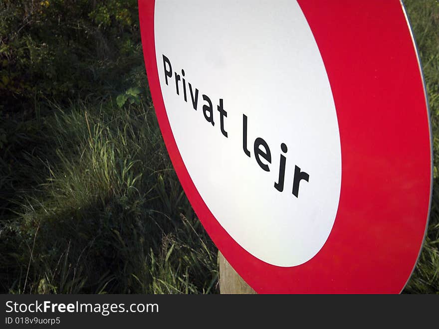 Private camp sign in red and white and in Danish language on private property. Private camp sign in red and white and in Danish language on private property