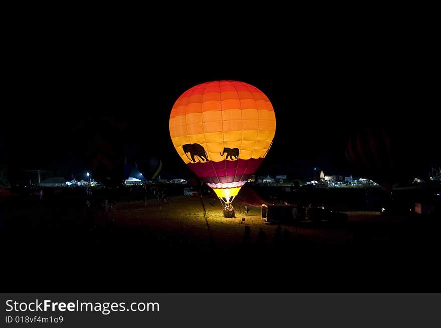 A hot air balloon glowing at night.