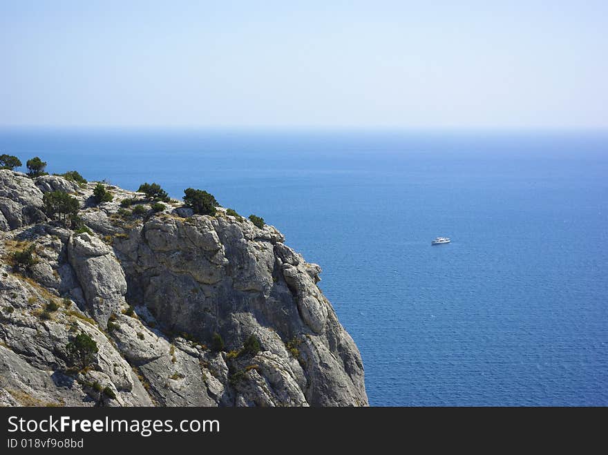 Vegetated abrupt cliff against blue horizon. Vegetated abrupt cliff against blue horizon