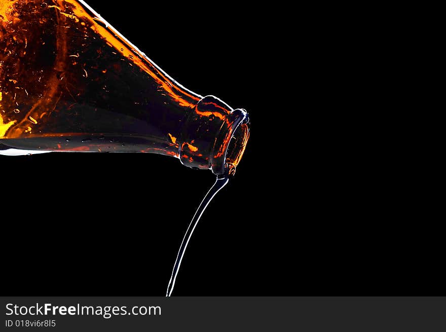 Close-up water flowing from bottle isolated on black