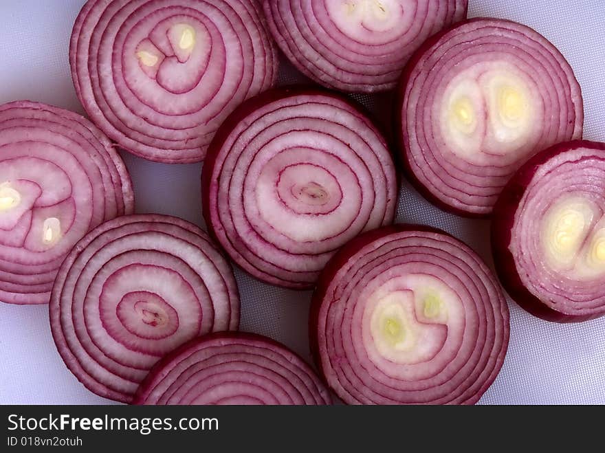 Onion rings sliced and laid out on a chopping board