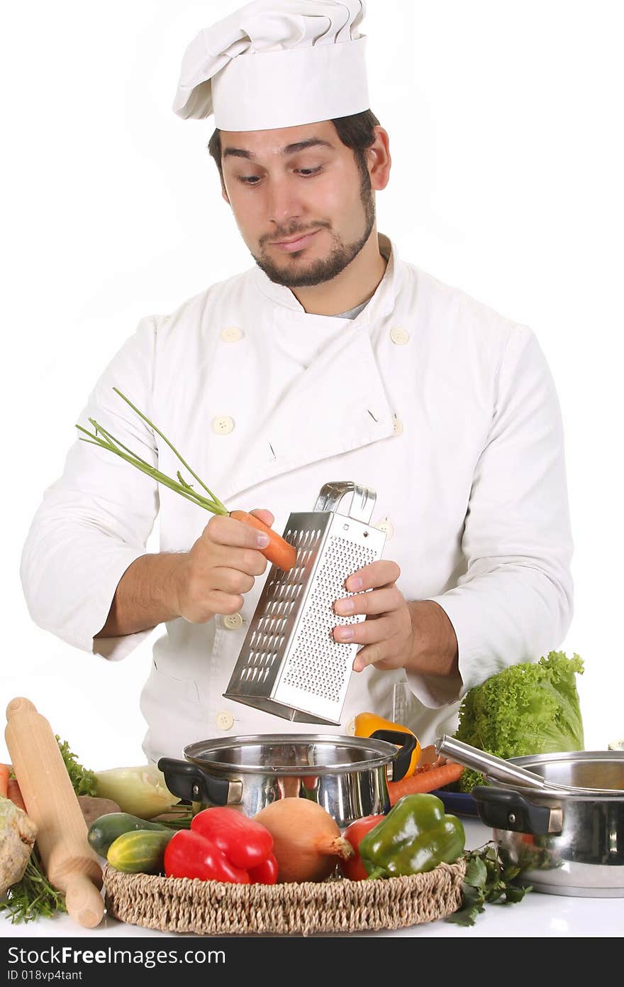 Young chef preparing lunch and cutting carrot with stainless grater