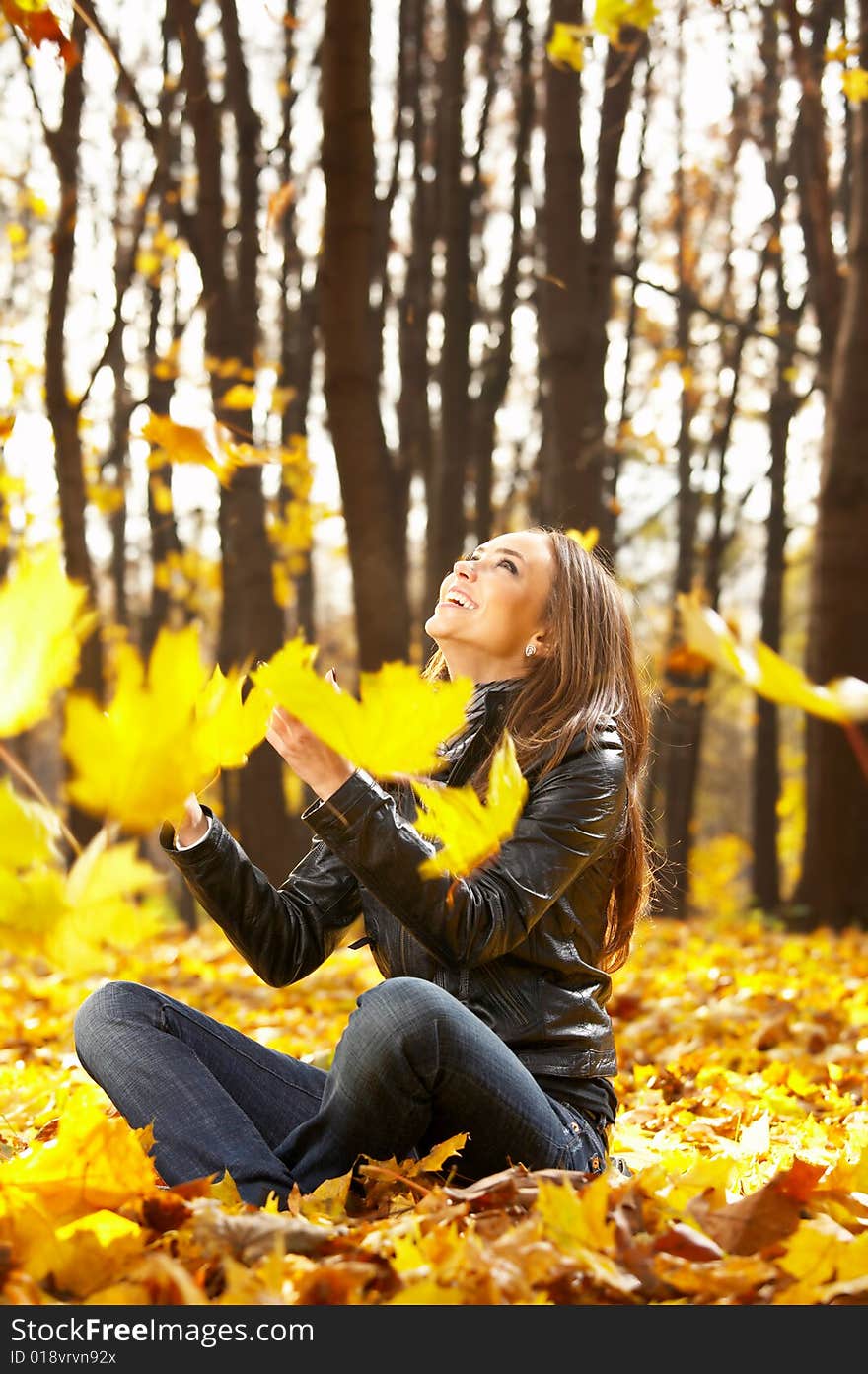 The laughing girl throws autumn leaves in park. The laughing girl throws autumn leaves in park