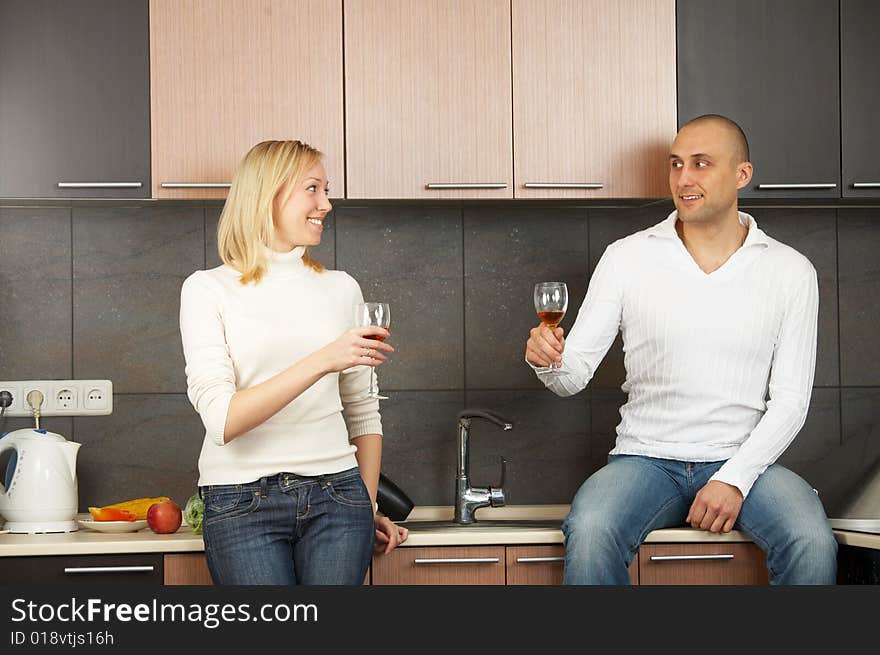 Smiling pair on kitchen with glasses in hands. Smiling pair on kitchen with glasses in hands