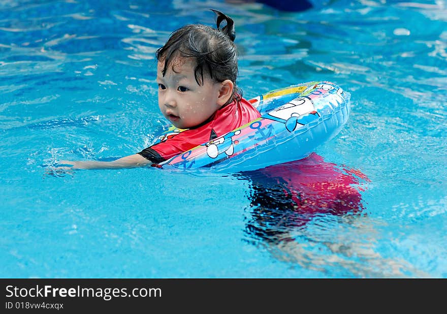 Beautiful little girl swimming in the swimming pool. Beautiful little girl swimming in the swimming pool