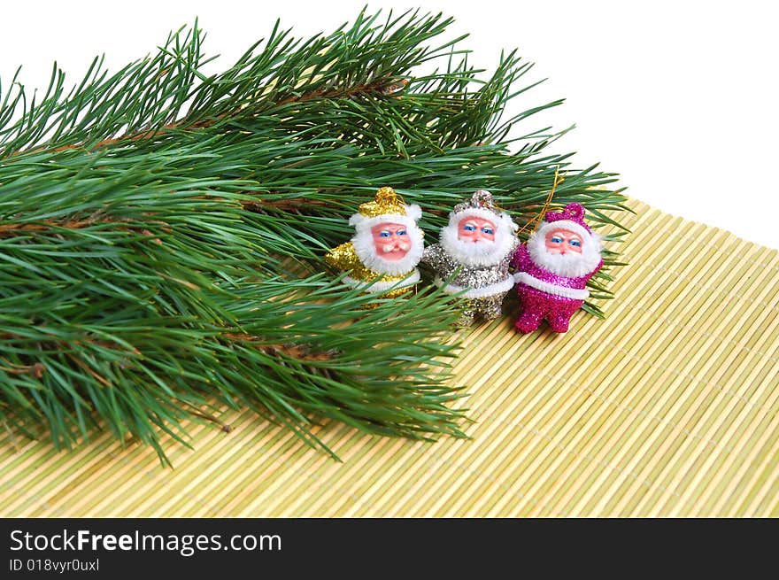 Three Santas sitting on  bamboo mat and a pine tree