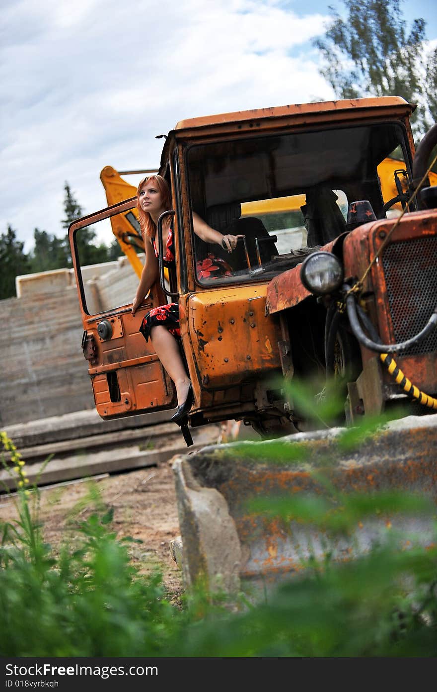 Beautiful young woman on tractor (summer time)