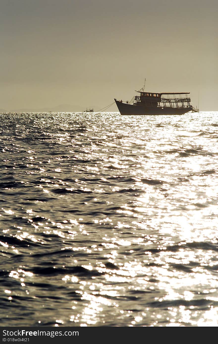 Silhouette of ship in sunlight toned sepia