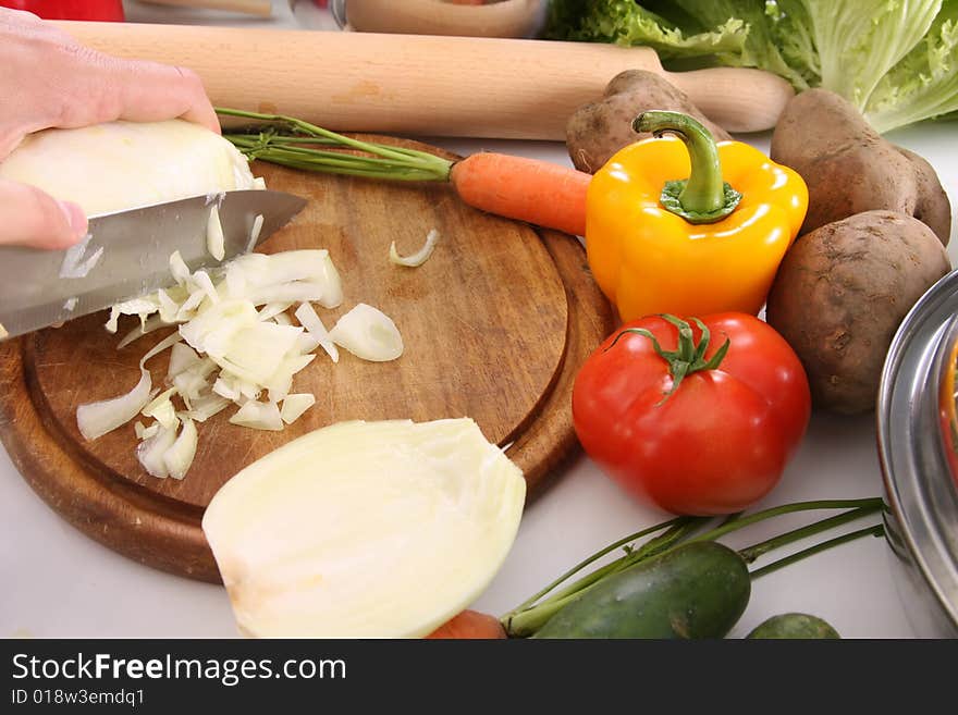 Chef preparing lunch and cutting onion with knife