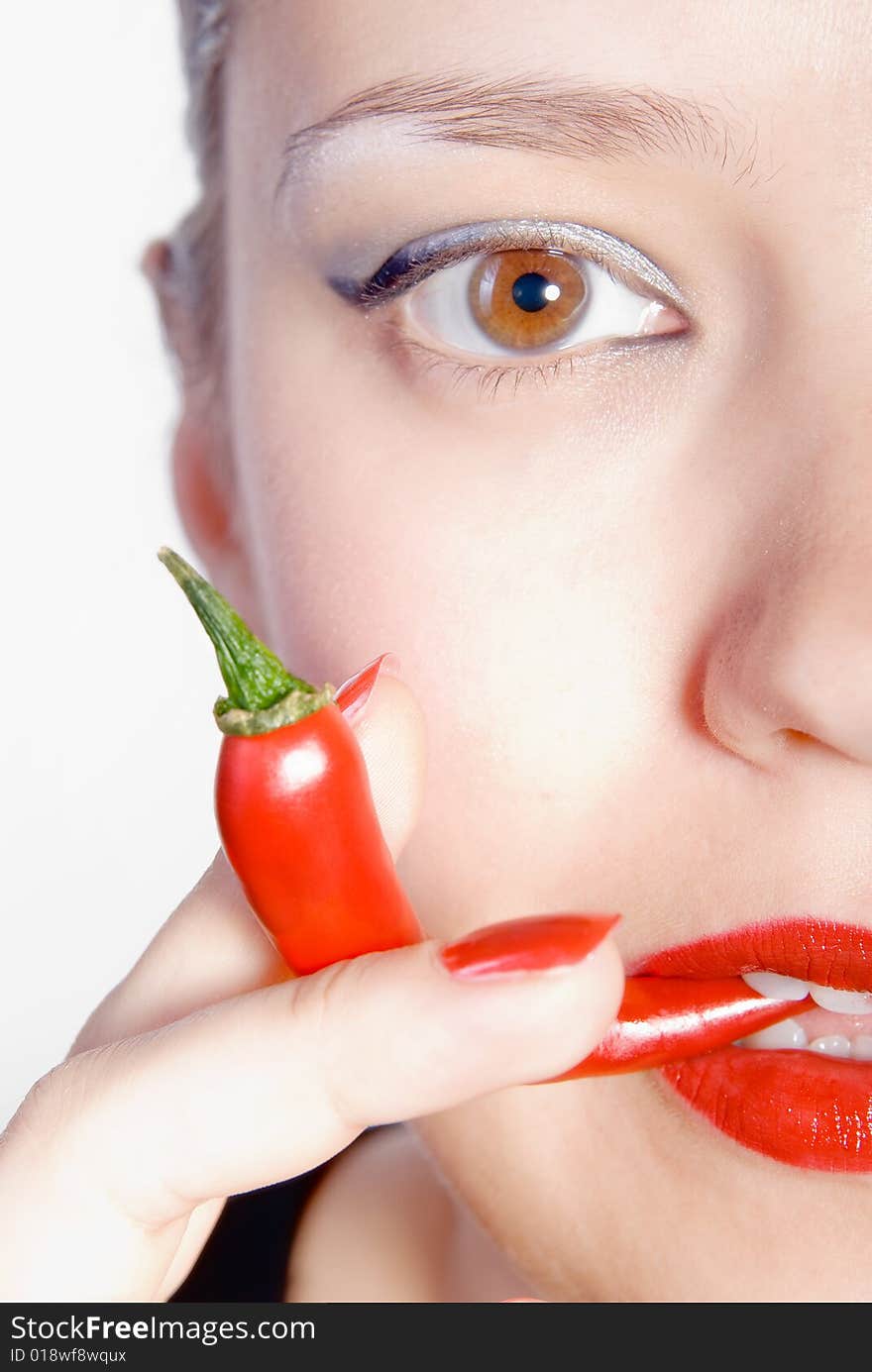 Girl is biting red hot chili pepper