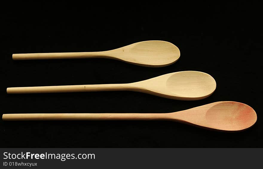 Three wooden spoons lined up on a table