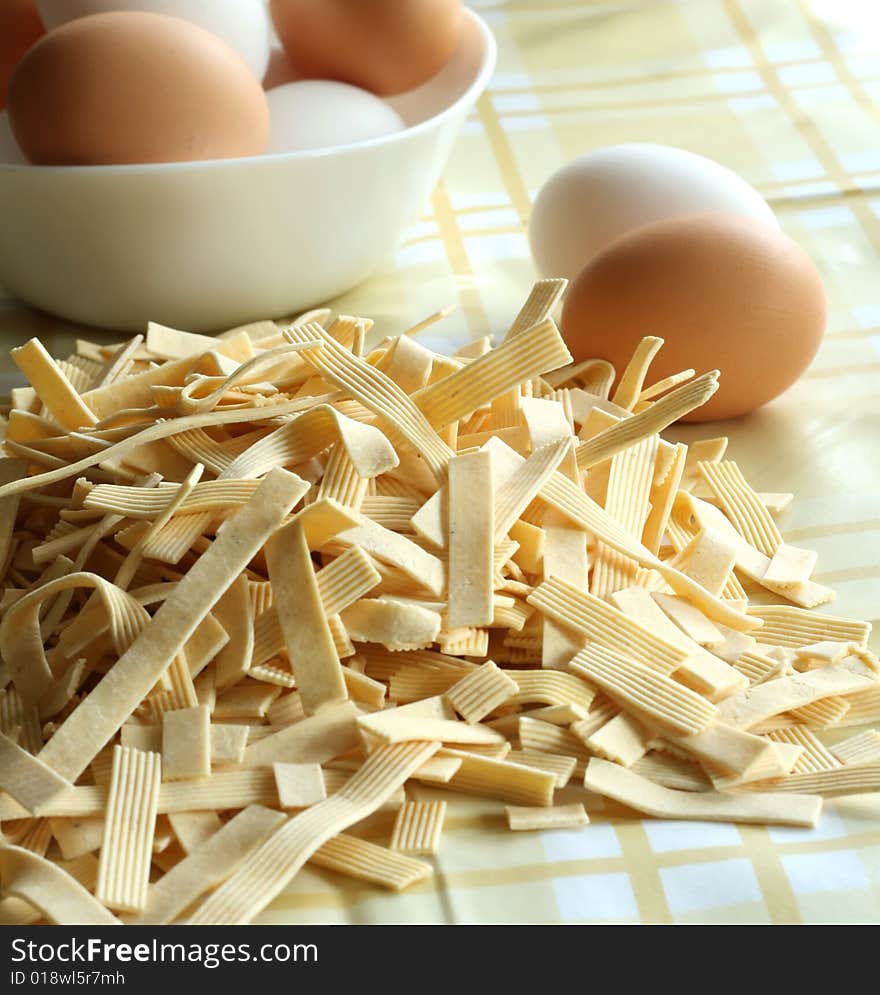 Egg noodles on a table and eggs