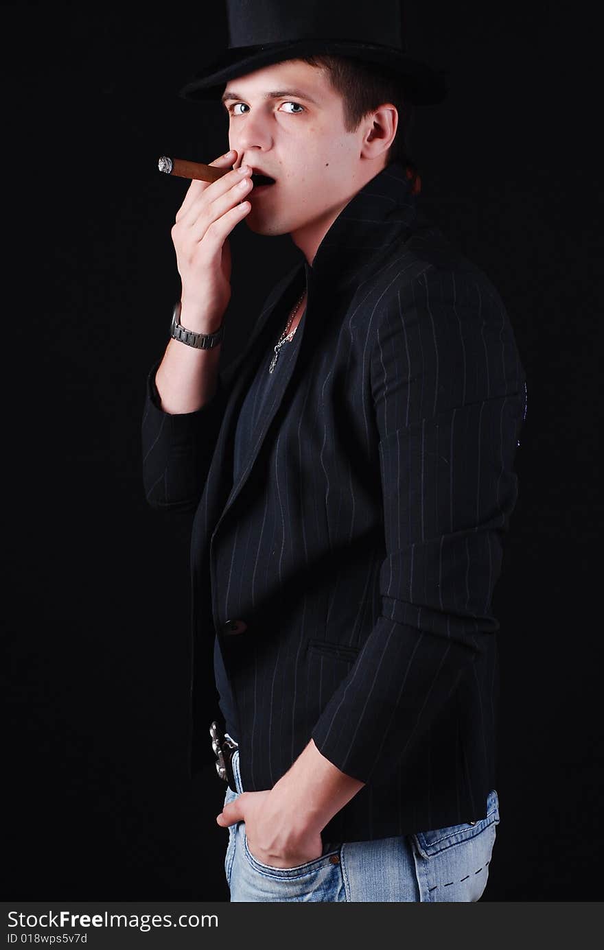 Portrait of young gangster in black suit with cigar. Portrait of young gangster in black suit with cigar