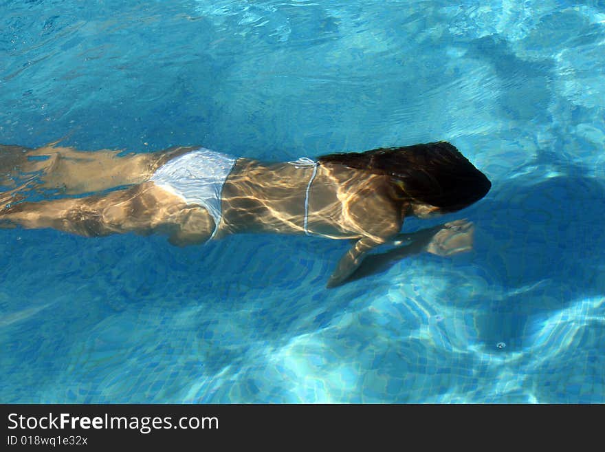 Woman in bikinis diving in the swimming pool. Woman in bikinis diving in the swimming pool