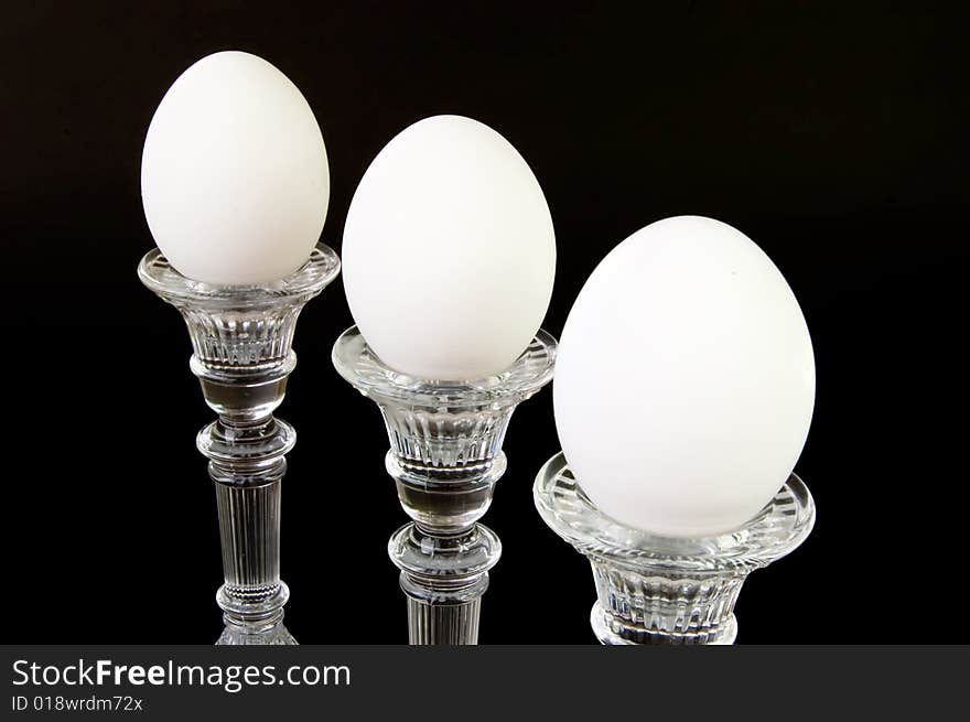 Three individual eggs on pedestals, on a black background. Three individual eggs on pedestals, on a black background