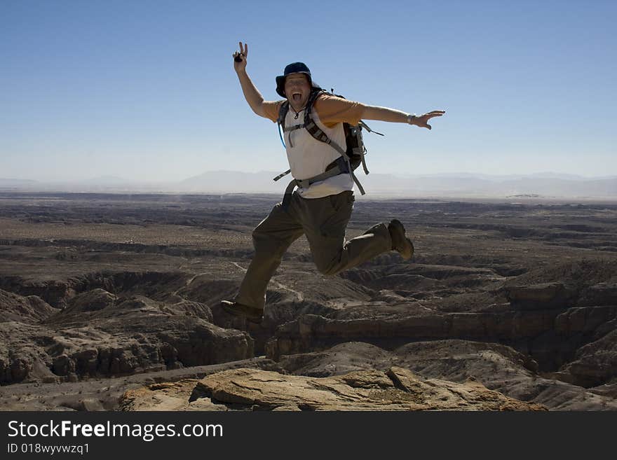 Male Hiker Jumping at an overlook of the Anza-Borrego Desert. Male Hiker Jumping at an overlook of the Anza-Borrego Desert