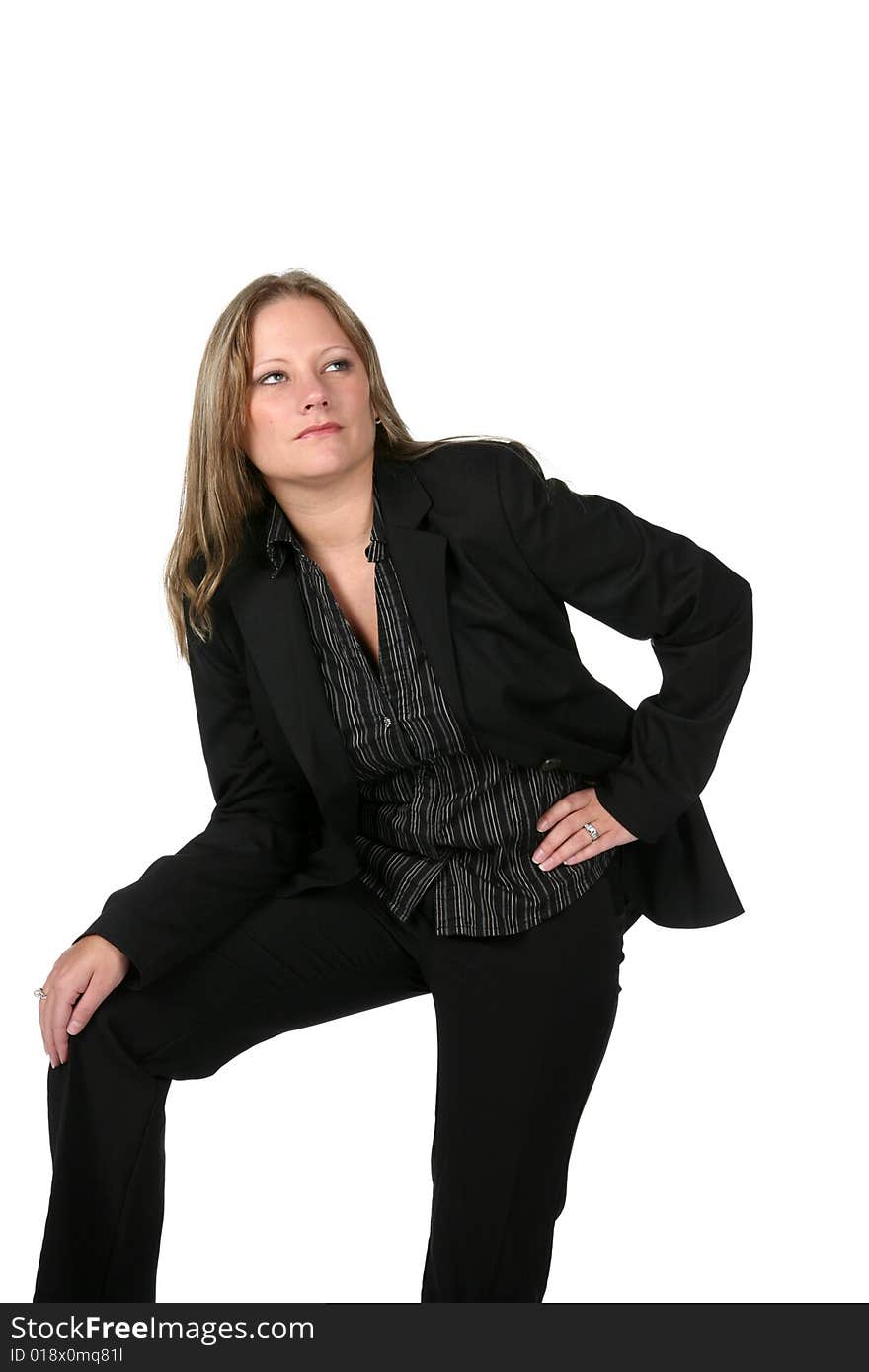 Pretty woman in black business suit with knee up and thoughtful expression on her face