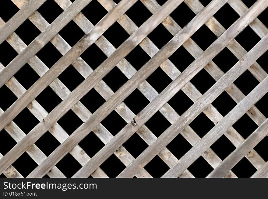 A lattice wooden fence isolated on black. A lattice wooden fence isolated on black.