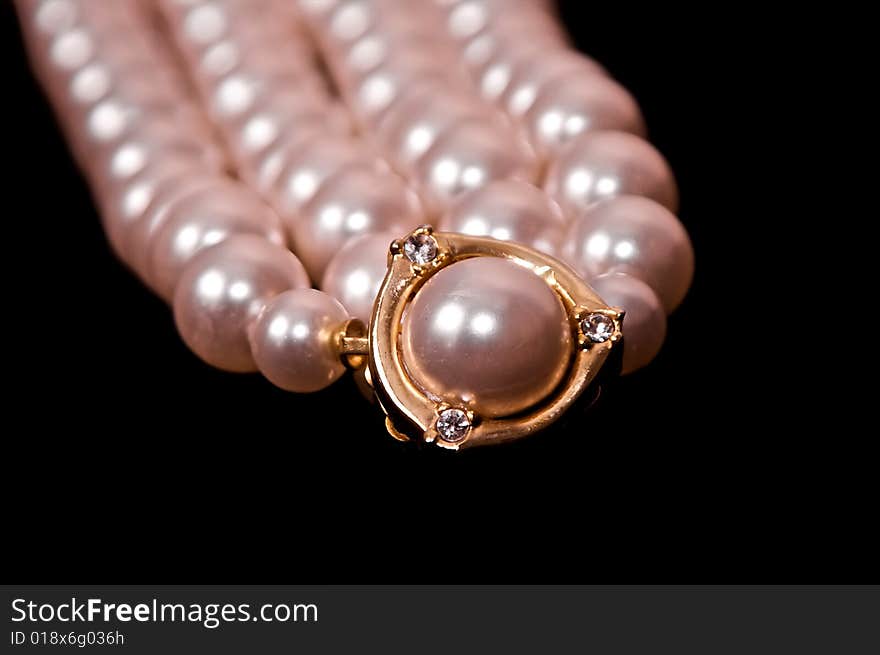 Close up of large pearl surrounded by diamonds and gold