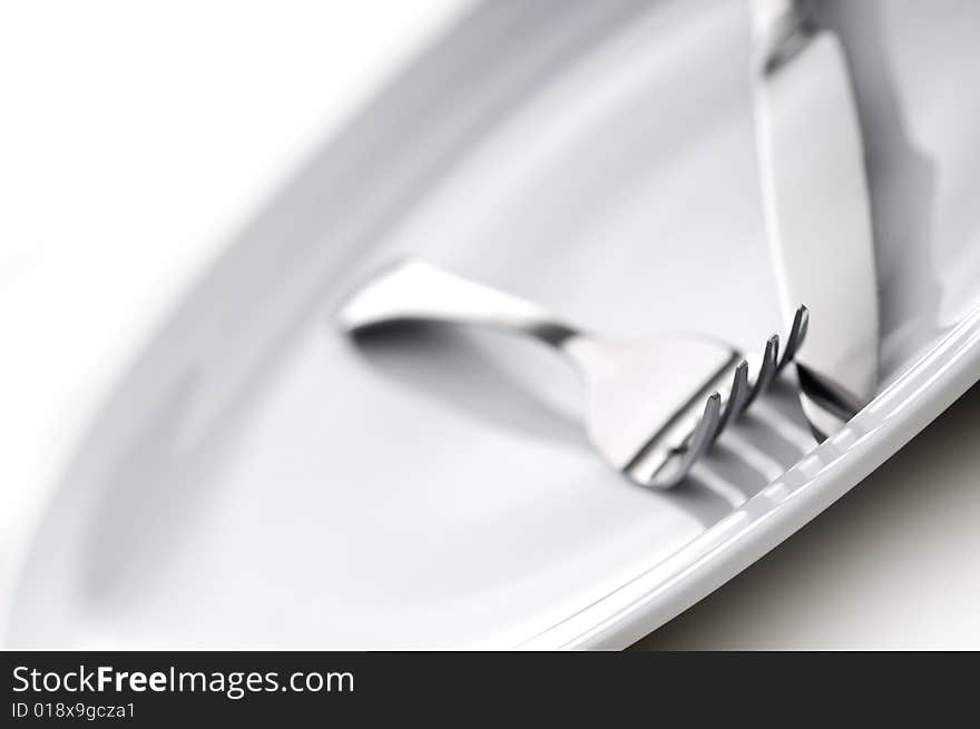 Shallow focus silverware on a white plate