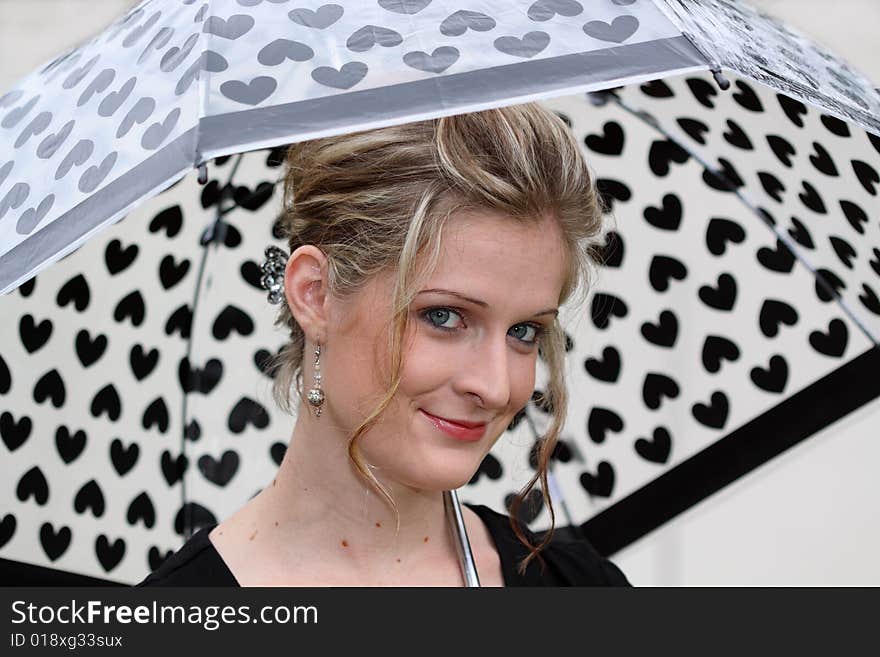 Young smiling woman holding an umbrella. Young smiling woman holding an umbrella.