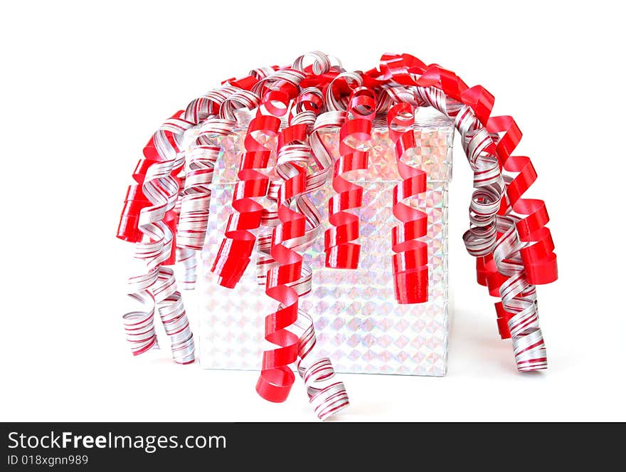 Gift wraped in metallic paper with red, white and silver ribbon isolated on white.