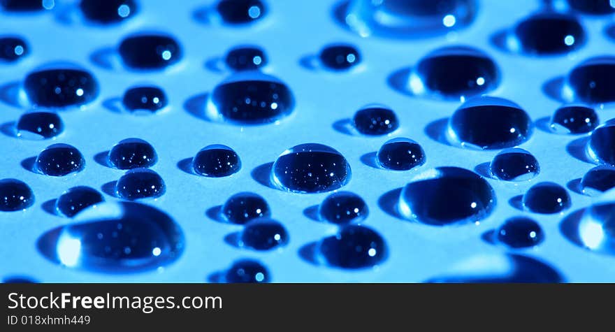 Abstract background with water drops on blue glass