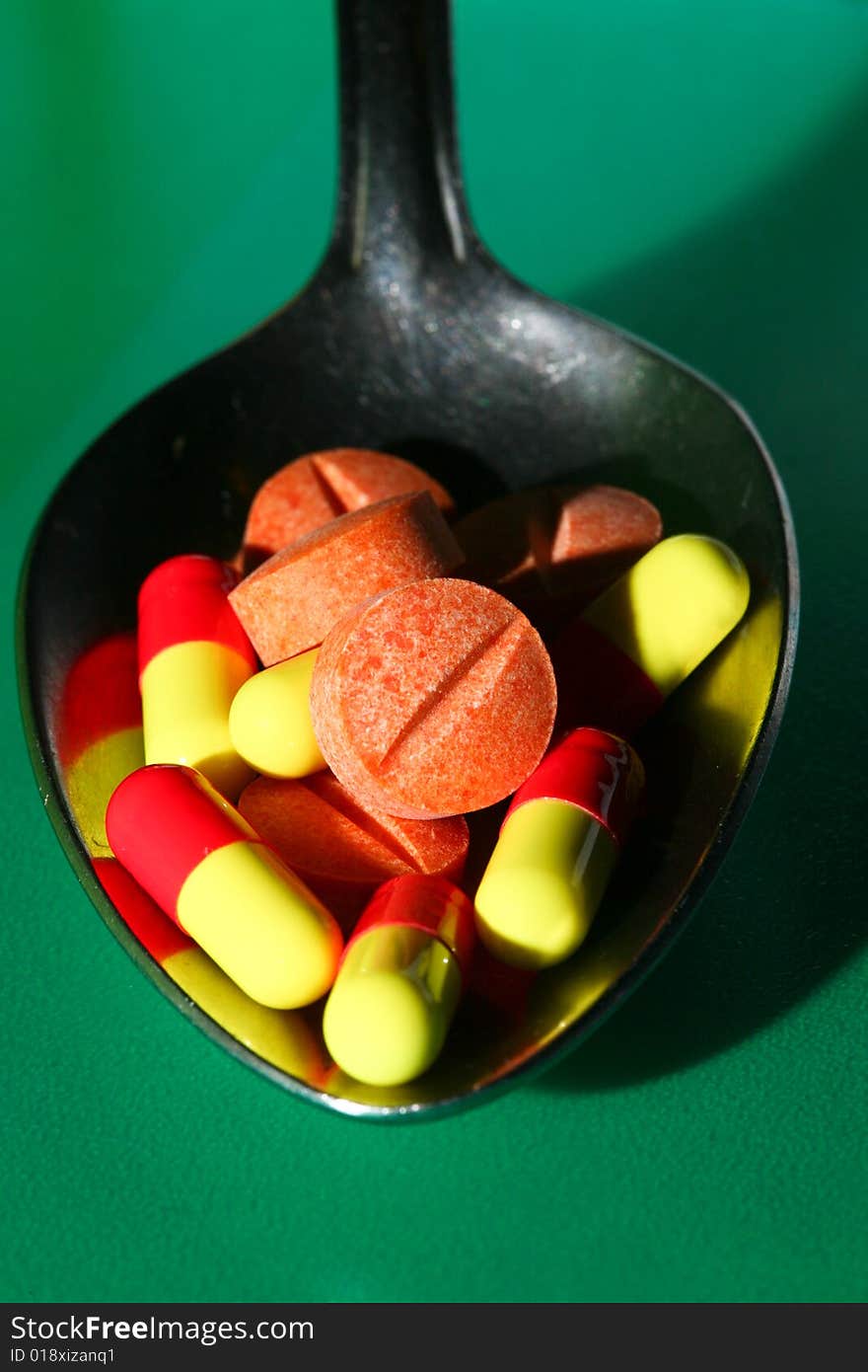 A stock of pills in iron spoon