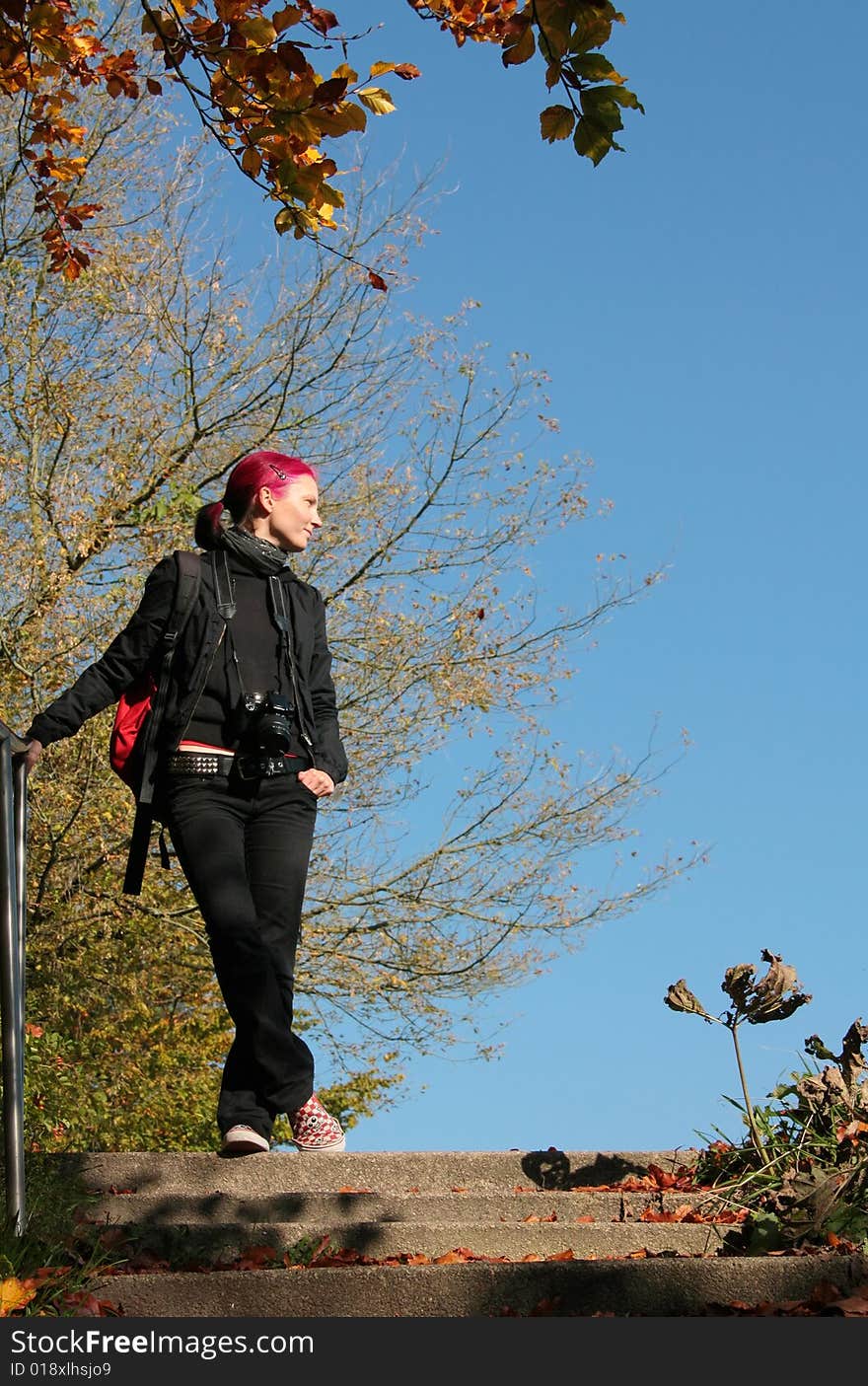 Young woman with coloured red hair standing on top of staircase. Young woman with coloured red hair standing on top of staircase