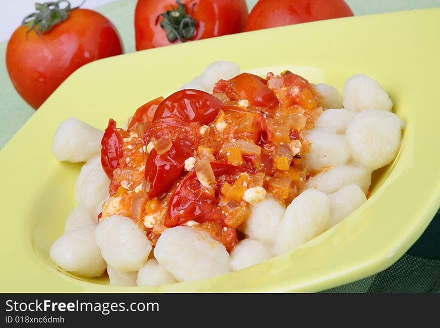 Potato noddles with tomato sauce on plate