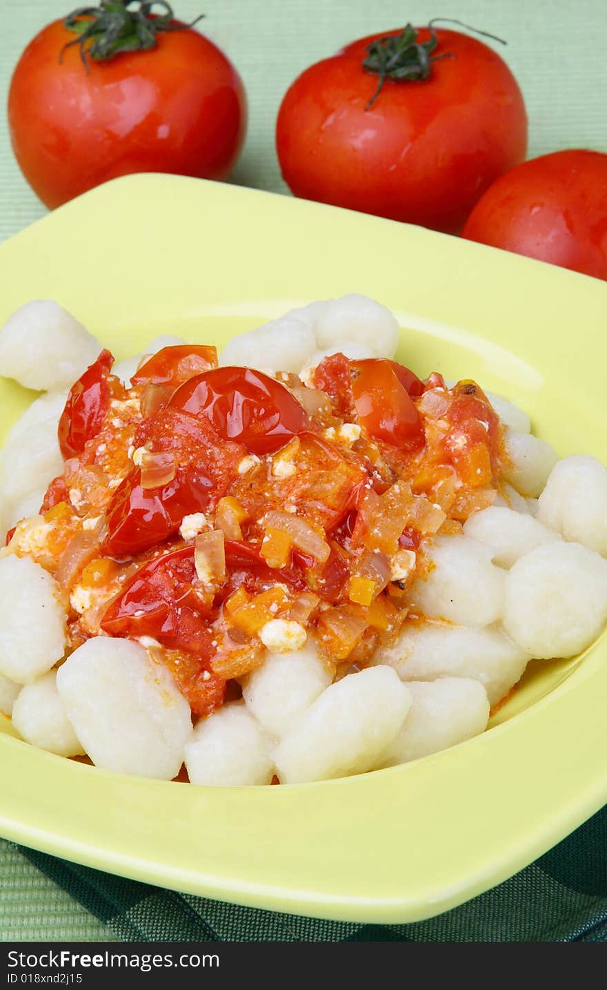 Potato noddles with tomato sauce on plate