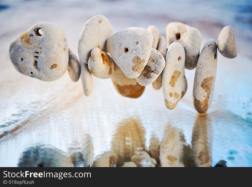 Stones are reflected in a wave