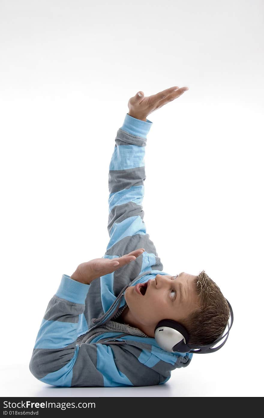 Laying young man with headphone looking upside against white background