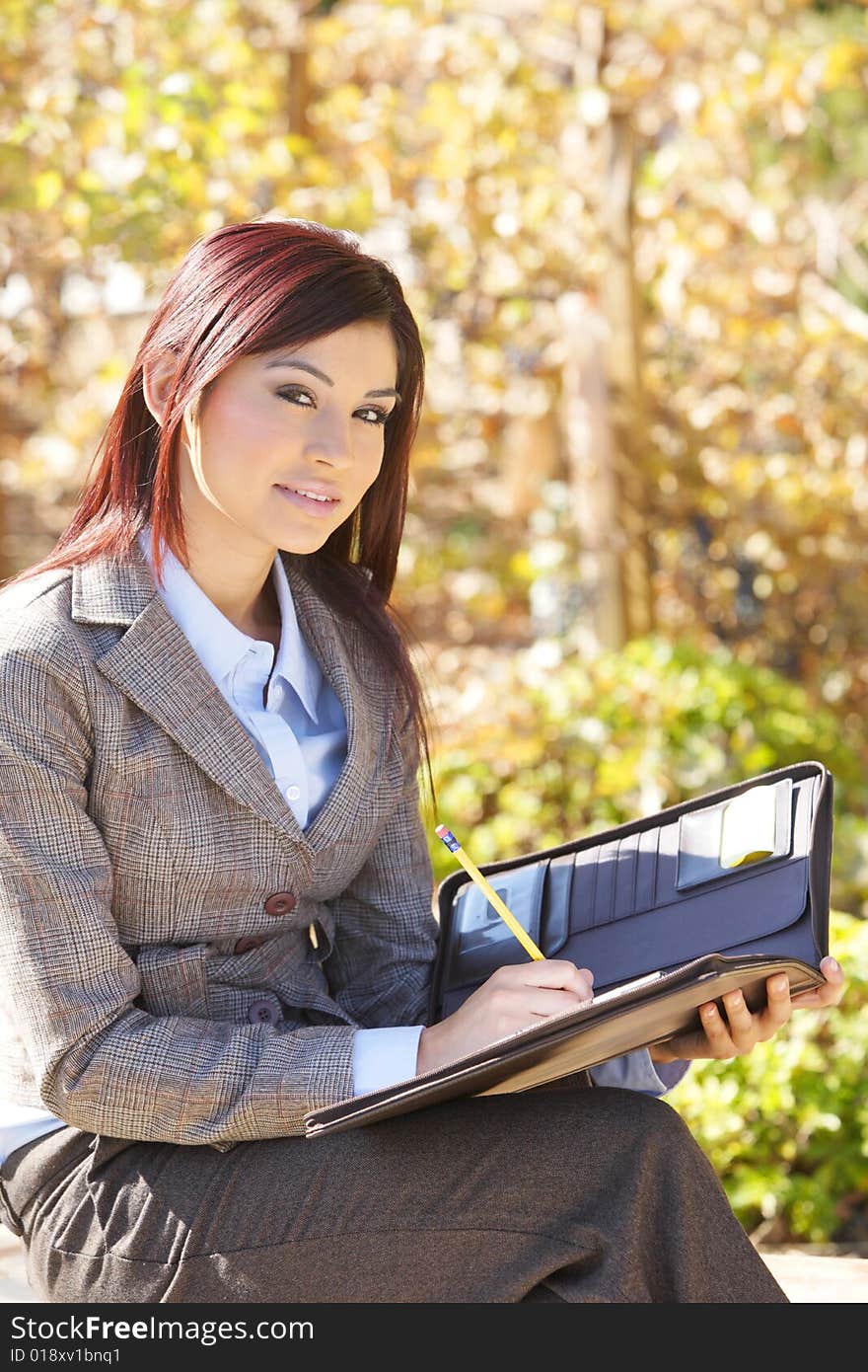 Business woman taking notes outside