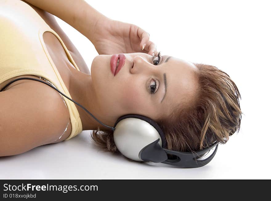 Laying woman with headphone looking at you