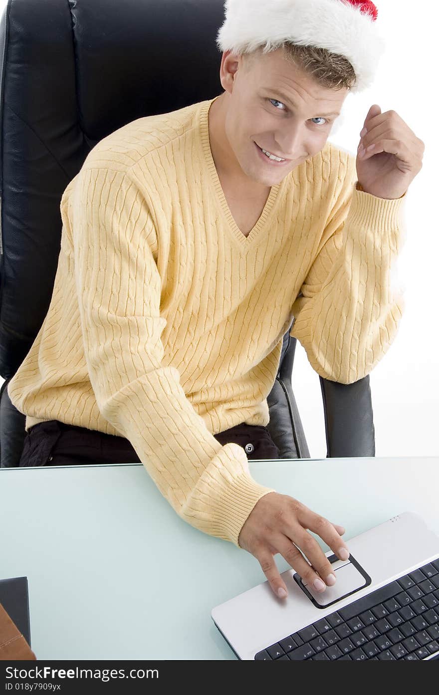 Male wearing Santa hat and working on laptop with white background. Male wearing Santa hat and working on laptop with white background