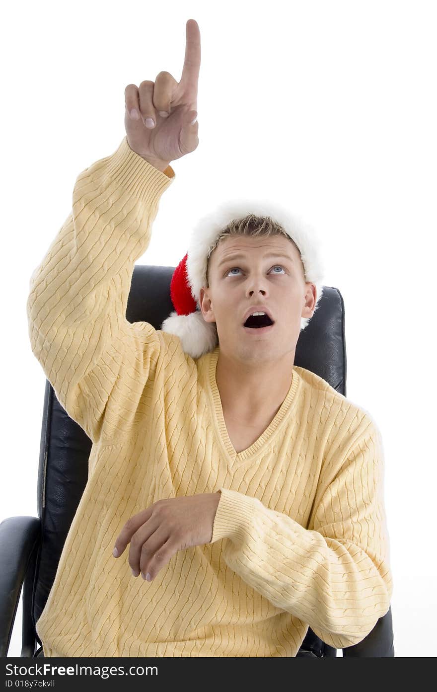 Man wearing christmas hat pointing upward against white background