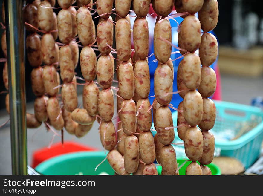 An image of a street peddler selling sausages by the side of the road. An image of a street peddler selling sausages by the side of the road