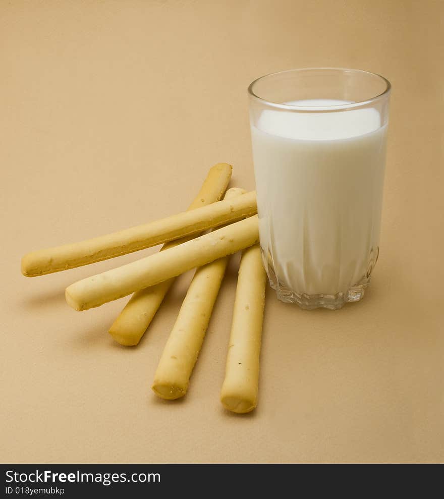 Cakes with milk glass close-up isolated on beige background