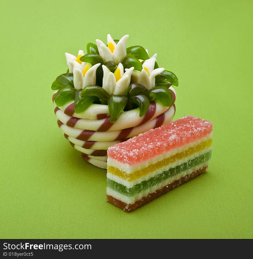 Colorful fruit jellies close-up isolated on green background