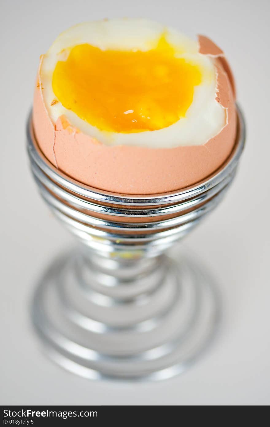 Brown egg in an eggcup on white background