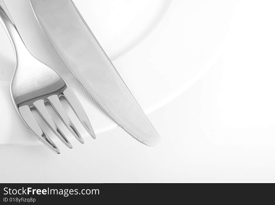 A knife and a fork on a plate. A knife and a fork on a plate