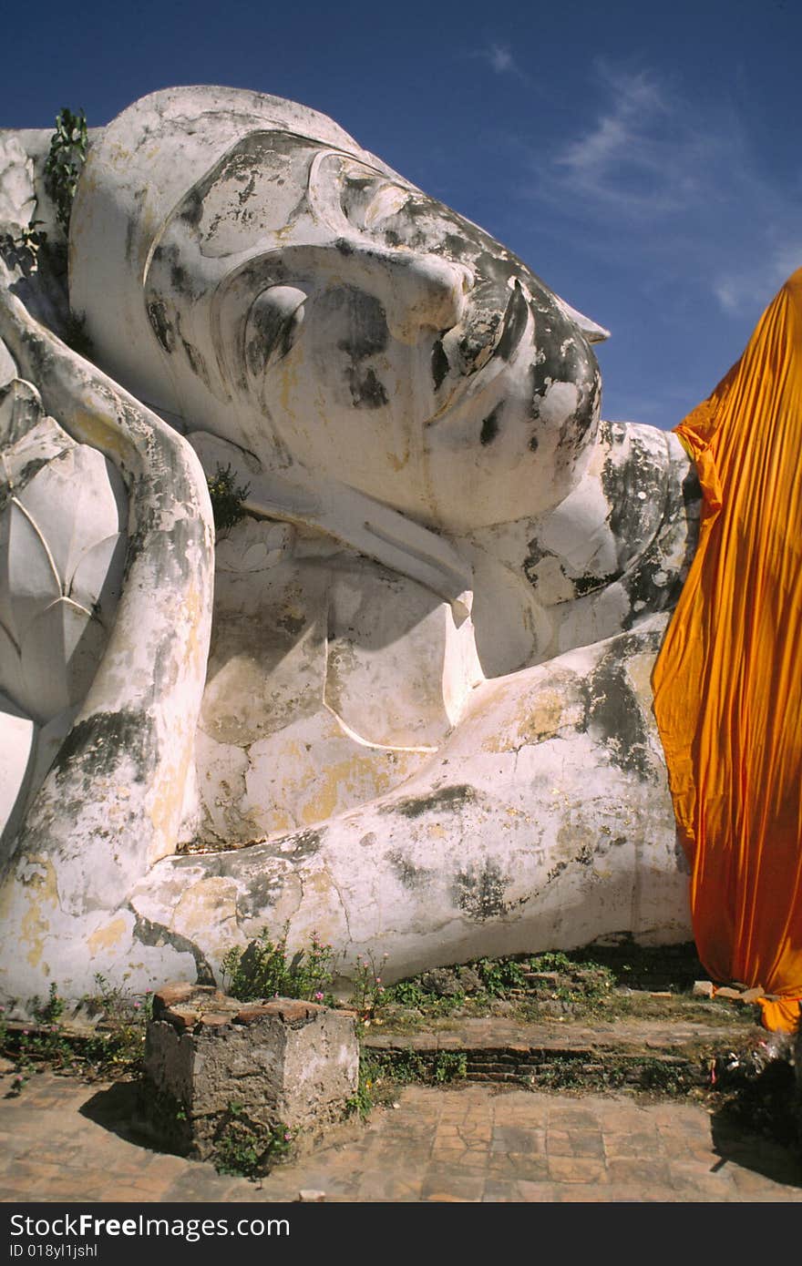 Giant reclining stone Buddha, covered with orange cloth. Ayutthaya, Thailand. Giant reclining stone Buddha, covered with orange cloth. Ayutthaya, Thailand