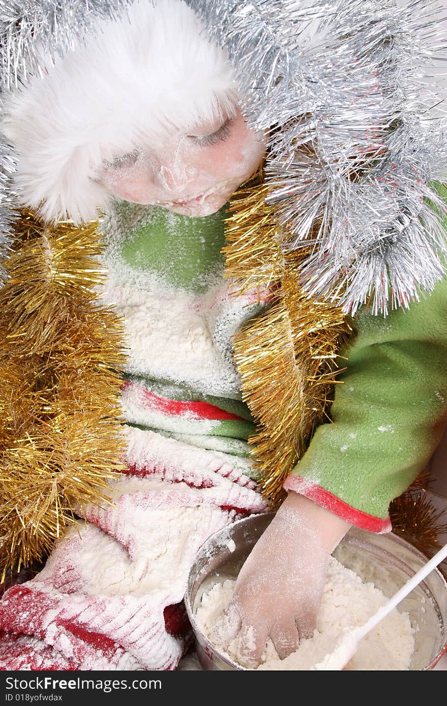 Toddler wearing a christmas hat, baking christmas cookies