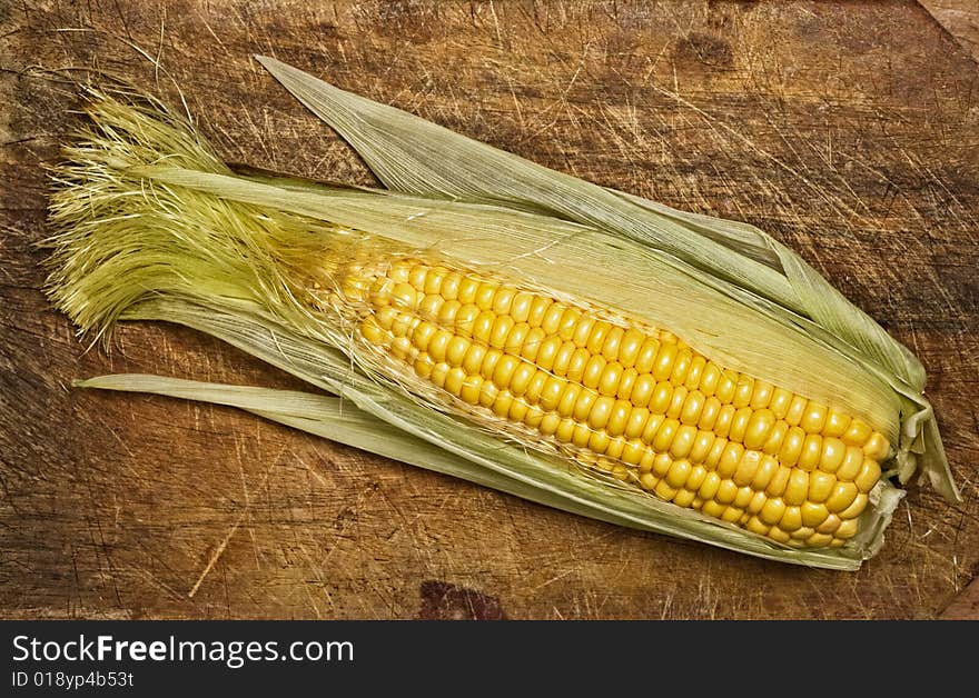 Corn on the cob, isolated on wooden table. Corn on the cob, isolated on wooden table.