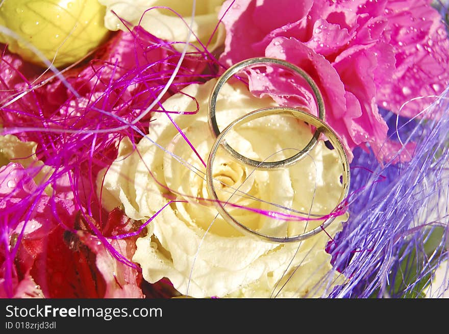 Two wedding rings made of white gold on the bright bouquet. Two wedding rings made of white gold on the bright bouquet